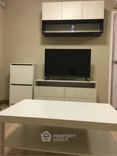 Modern living room with sleek furniture and flat-screen TV, perfect for cozy relaxation.