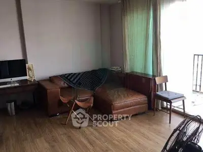 Cozy living room with leather sofa and natural light, perfect for relaxation.