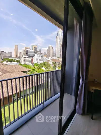 Stunning city view from modern apartment balcony with sliding glass doors.