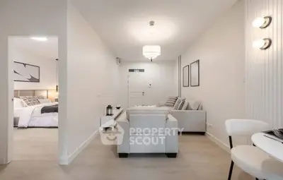 Modern living room with elegant decor and cozy seating, adjacent to a stylish bedroom, perfect for urban living.