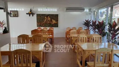 Charming dining area with wooden tables and vibrant plants, perfect for cozy gatherings.