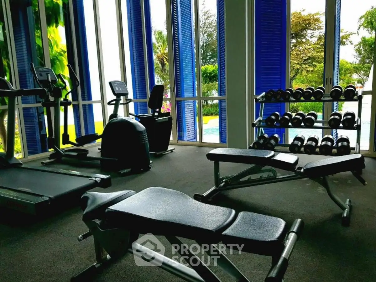Luxurious gym with modern equipment and pool view in upscale property