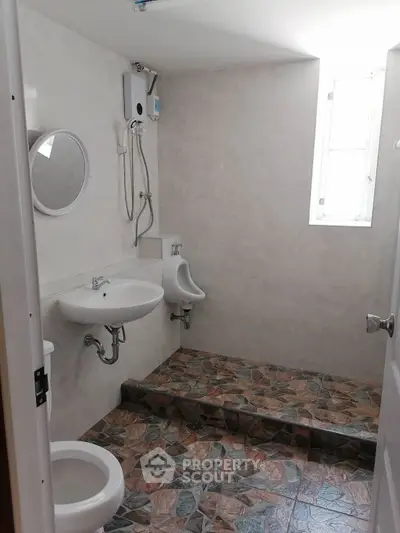 Modern bathroom with unique tile flooring and natural light