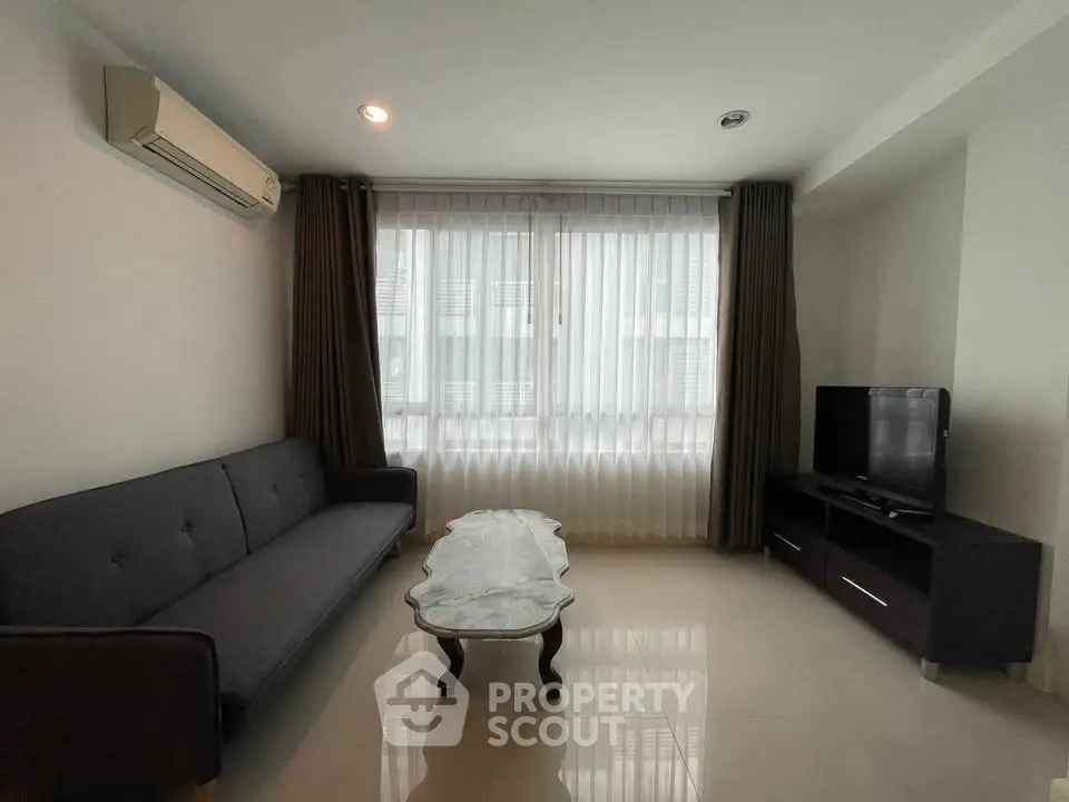 Modern living room with sleek furniture and large window for natural light.