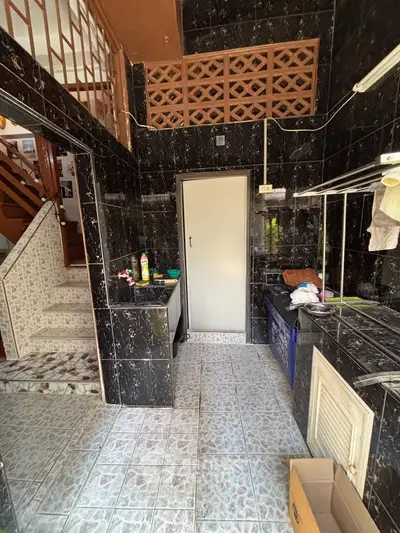 Charming kitchen with unique tile design and open layout, featuring a staircase leading to upper levels.
