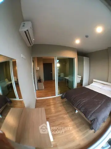 Modern bedroom with mirrored closet and wooden flooring in a stylish apartment.