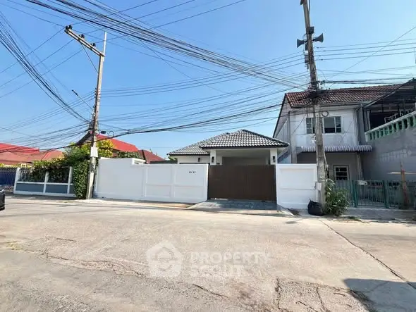 Charming suburban house with gated entrance and tiled roof, perfect for family living.