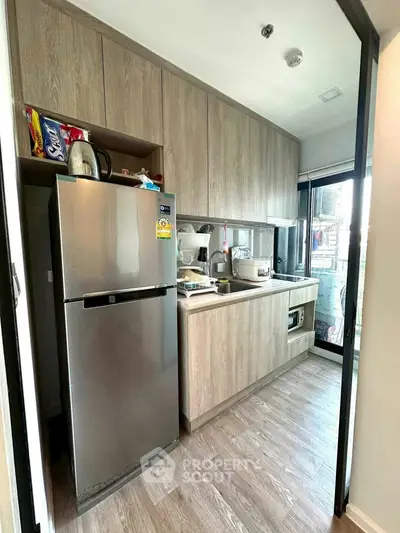 Modern kitchen with sleek cabinetry and stainless steel appliances in a compact layout.