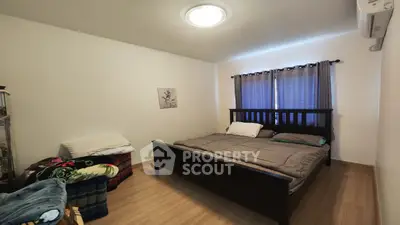 Cozy bedroom with modern bed and wooden flooring, ideal for restful nights.