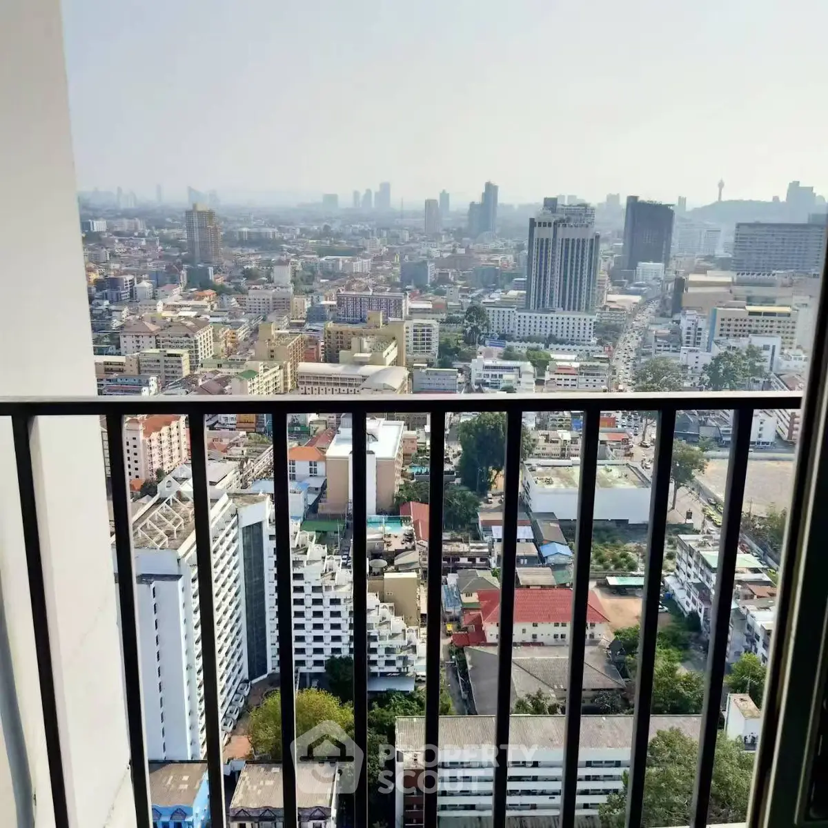 Stunning cityscape view from high-rise balcony overlooking urban skyline.