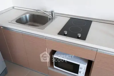 Modern kitchen with sleek countertop, electric stove, and built-in microwave for efficient cooking.