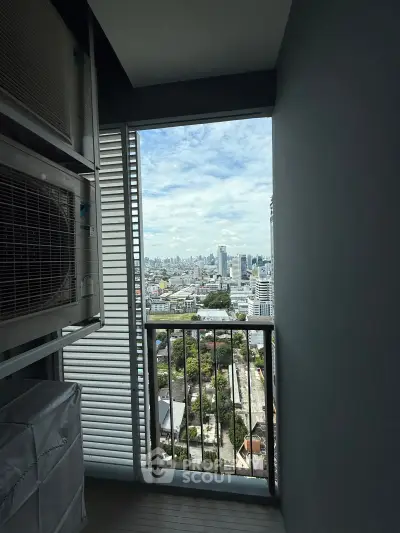 Stunning cityscape view from a high-rise balcony with modern railing and air conditioning unit.