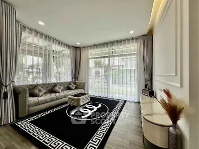 Luxurious living room with elegant decor and large windows offering garden views.