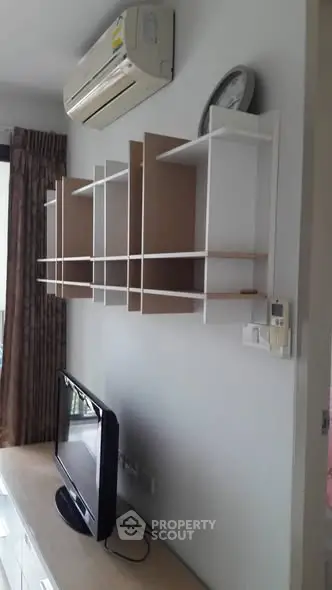 Modern living room with wall-mounted shelves and air conditioning unit