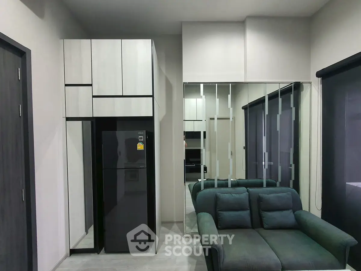 Modern living room with sleek furniture and mirrored wall enhancing space