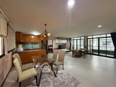 Spacious open-plan living and dining area with modern kitchen and large windows.