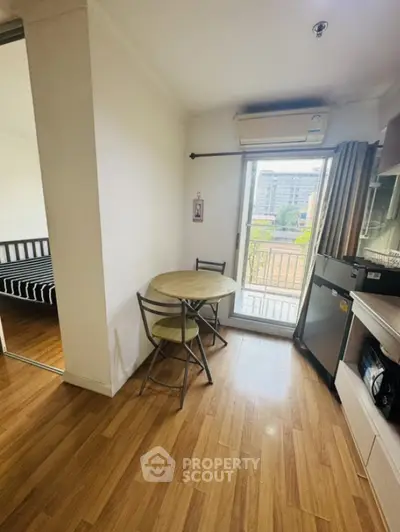 Cozy apartment dining area with wooden flooring and balcony view