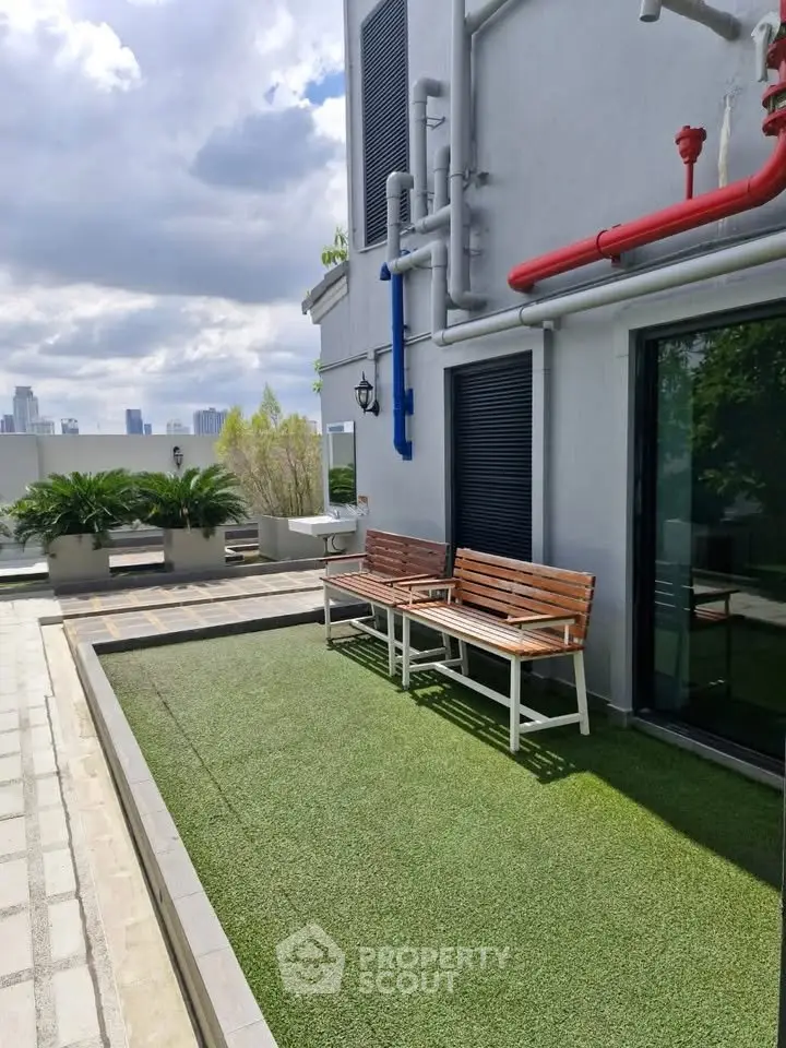 Modern building exterior with artificial grass and city skyline view