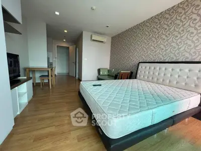 Spacious bedroom with modern decor and wooden flooring in a stylish apartment.