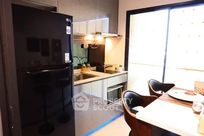 Modern kitchen with sleek black fridge and dining area