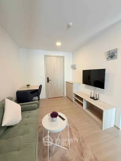 Modern living room with stylish furniture and wall-mounted TV in a cozy apartment.