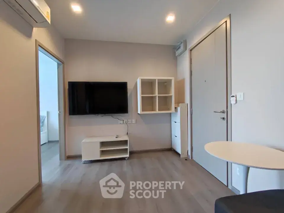 Modern living room with wall-mounted TV and sleek furniture in a stylish apartment.