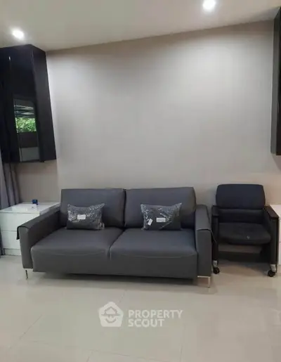 Modern living room with sleek gray sofa and armchair, perfect for contemporary urban living.