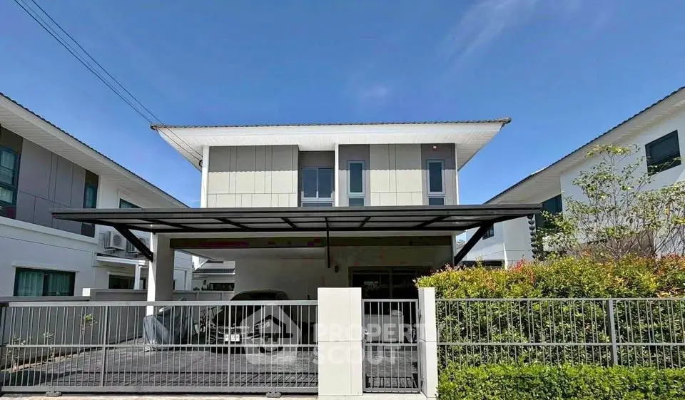 Modern two-story house with carport and landscaped garden in a suburban neighborhood.