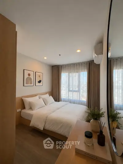 Modern bedroom with cozy decor and large window offering city views