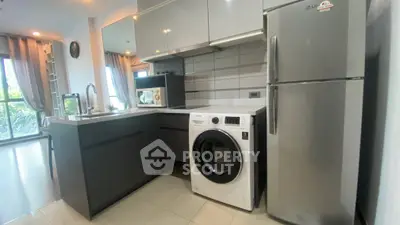 Modern kitchen with sleek appliances and washing machine in stylish apartment.