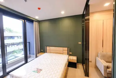 Modern bedroom with large windows and balcony access in a stylish apartment.