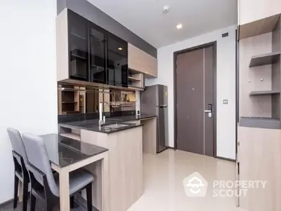 Modern kitchen with sleek cabinetry, integrated appliances, and a cozy dining area, perfect for urban living.