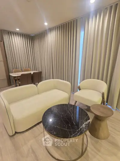 Modern living room with elegant furniture and floor-to-ceiling curtains