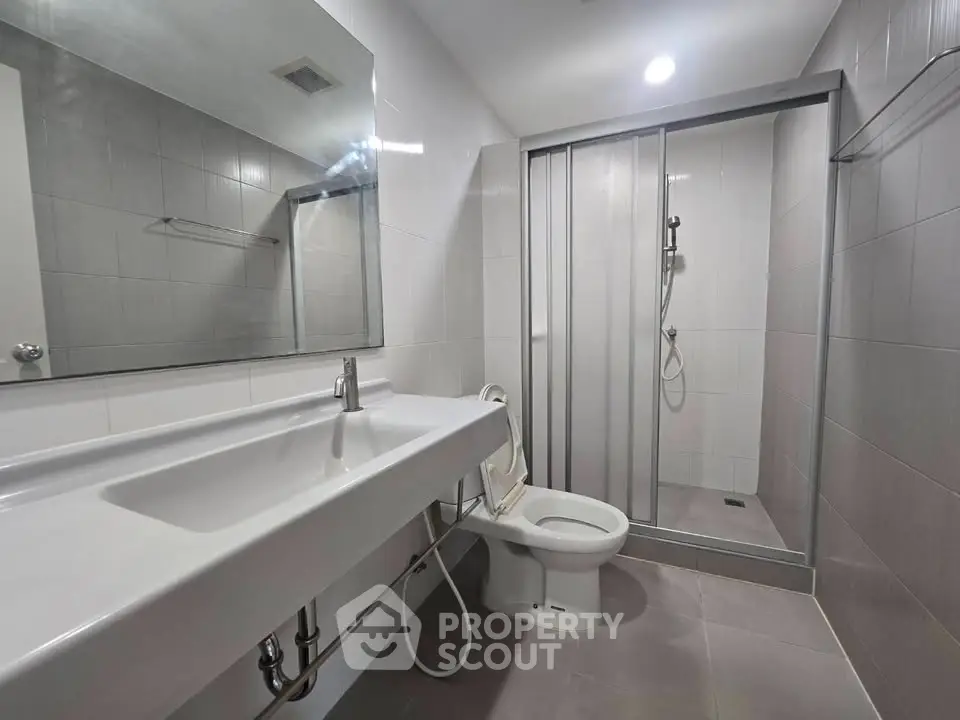 Modern bathroom with sleek design featuring a spacious shower and elegant fixtures.