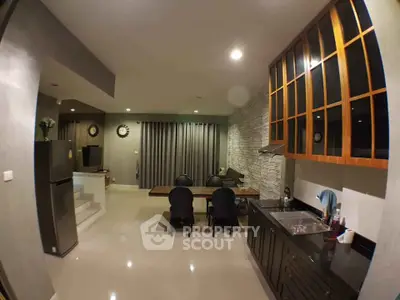Modern kitchen with sleek cabinetry and dining area in open layout design.