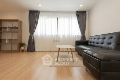 Modern living room with sleek black sofa and natural light