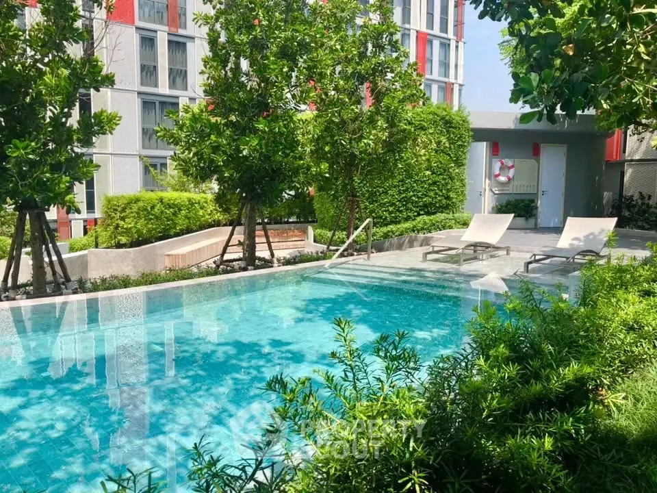 Luxurious apartment complex with serene outdoor pool and lush greenery