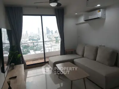 Modern living room with city view and sleek furniture in high-rise apartment.