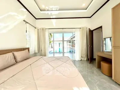 Spacious bedroom with pool view and elegant decor