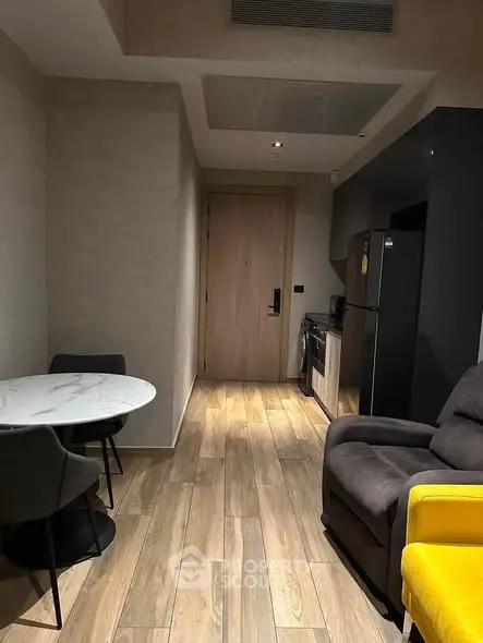 Modern apartment interior with cozy living area and compact kitchen featuring sleek appliances.
