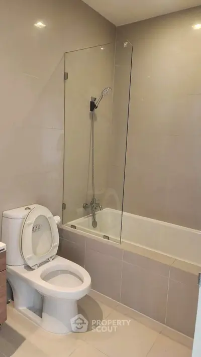 Modern bathroom with sleek bathtub and shower in a contemporary apartment.