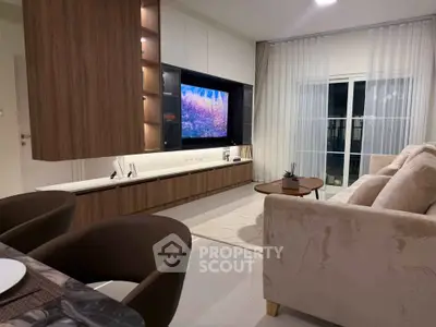 Modern living room with sleek furniture and large TV, perfect for relaxation.