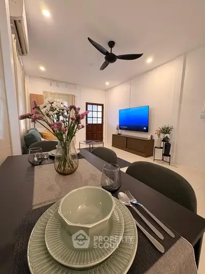 Modern living room with dining area, stylish decor, and large TV, perfect for entertaining.