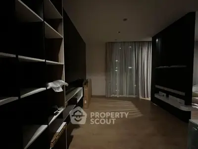 Spacious modern living room with floor-to-ceiling windows and elegant shelving units.