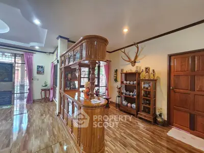 Spacious living room with wooden decor and elegant display shelves.
