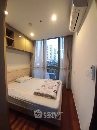 Cozy bedroom with city view, featuring a comfortable bed and modern air conditioning.