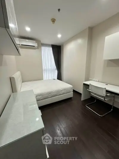 Modern bedroom with sleek furniture and natural light, perfect for urban living.