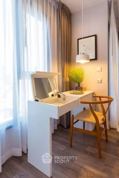 Chic study nook with natural light, modern desk, and stylish chair in cozy apartment corner.