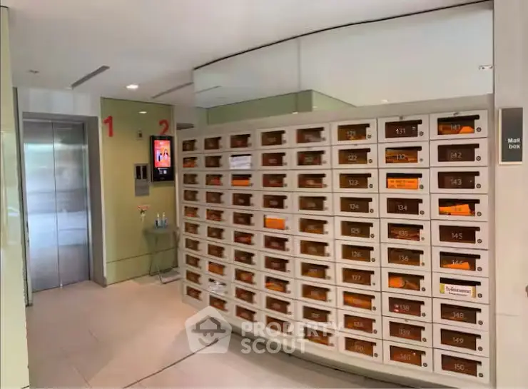 Modern apartment building lobby with mailboxes and elevator access.