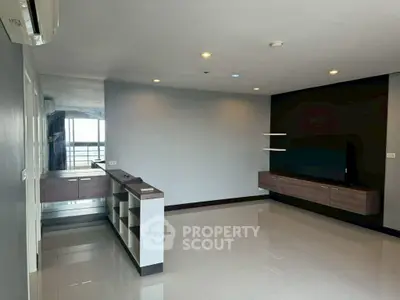 Spacious modern living room with sleek built-in furniture and glossy tile flooring